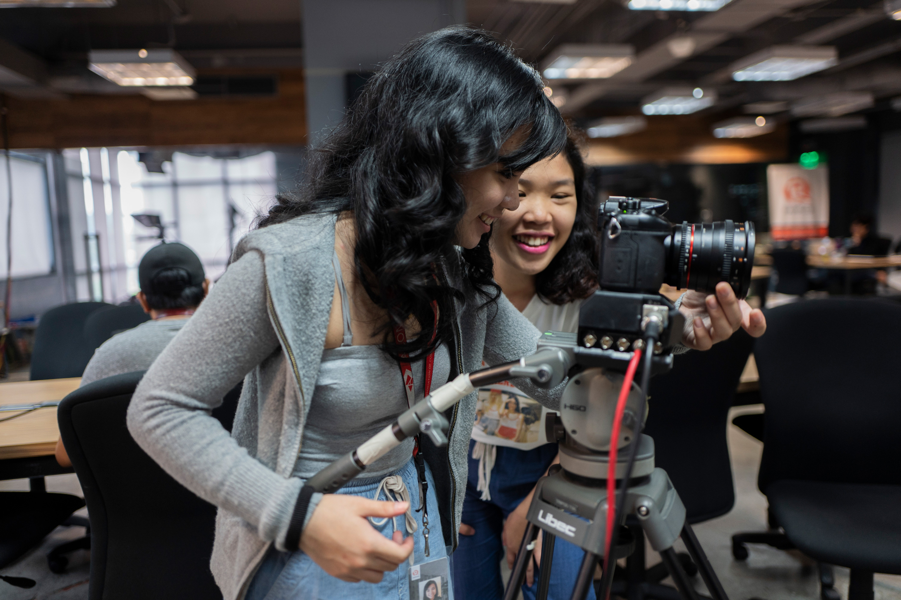 Two young women setting up a professional camera on a tripod