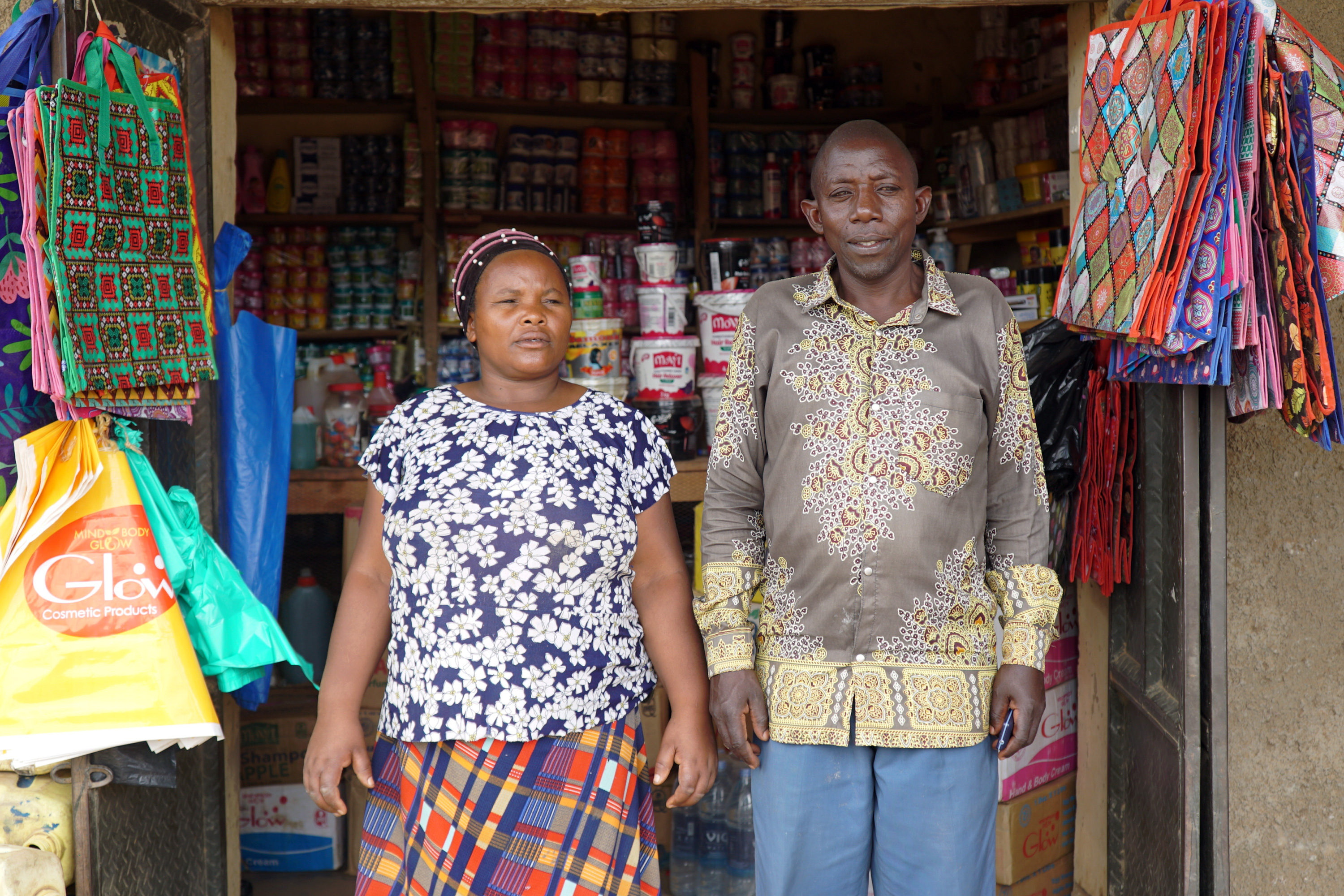 A man and woman standing in front of a store