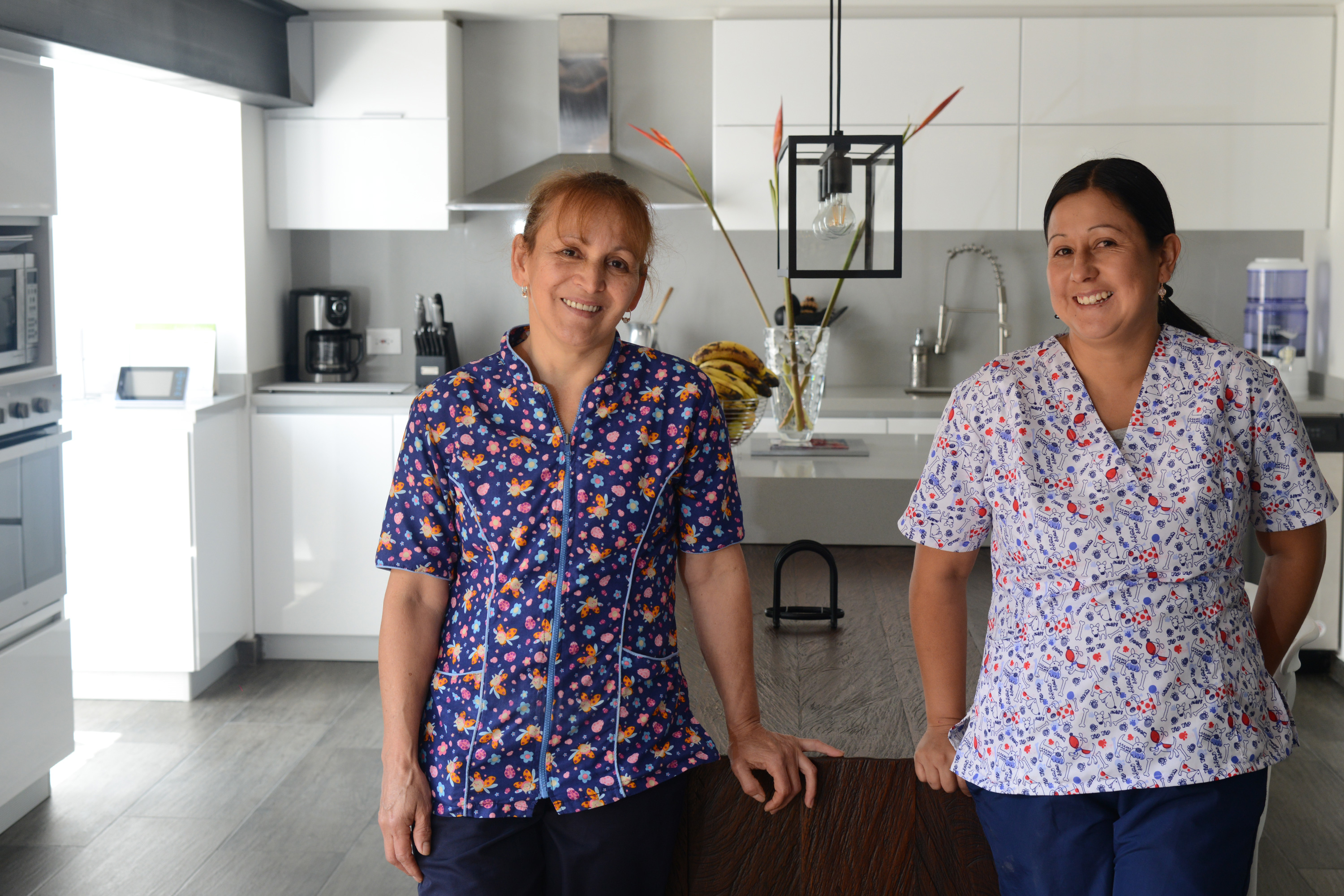 Two women stand in a kitchen