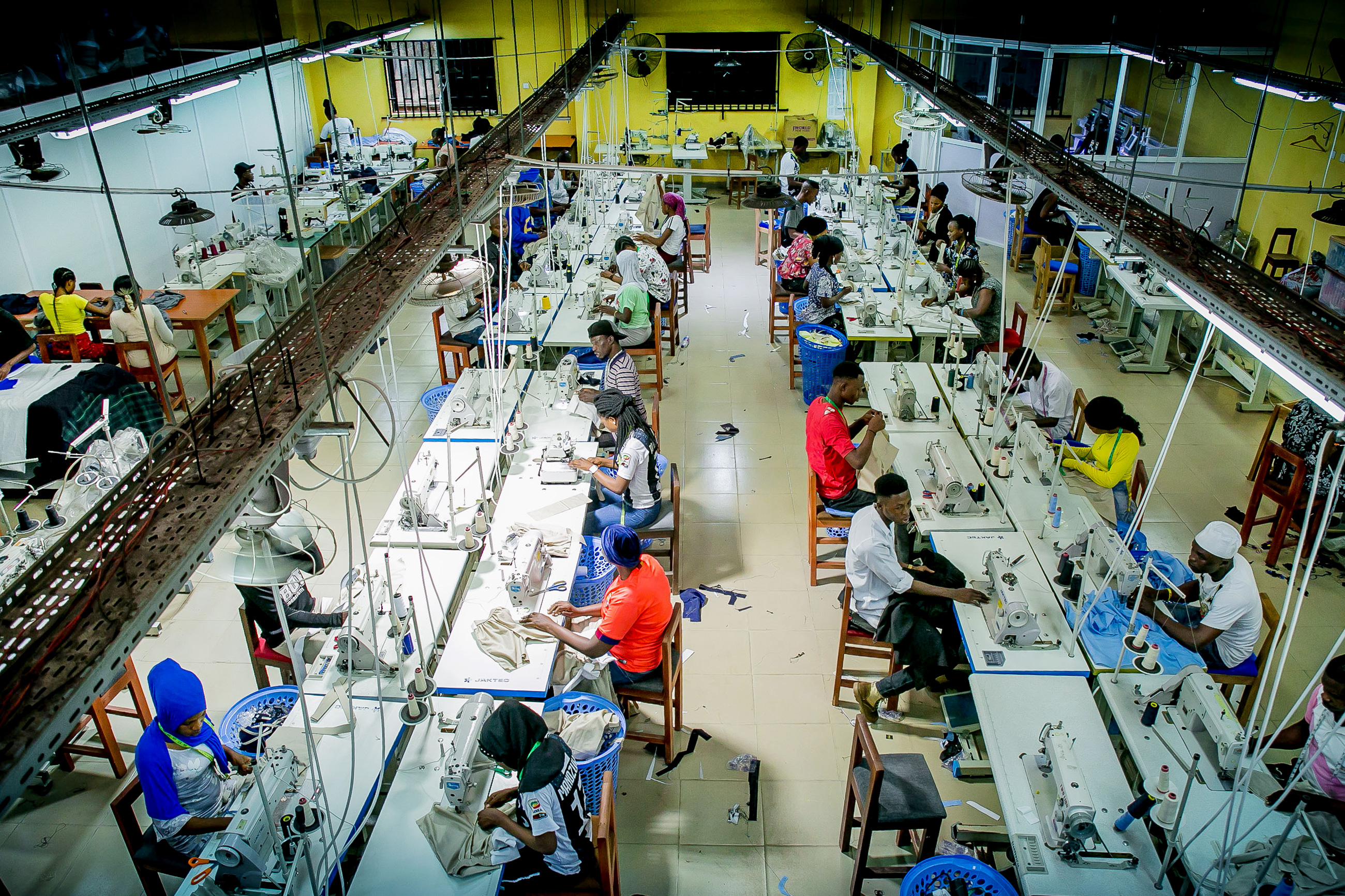 Workers in a factory sitting in front of sewing machines
