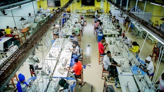 Workers in a factory sitting in front of sewing machines