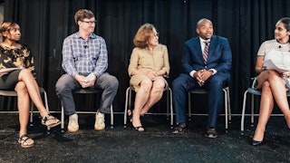 Five people sit on a stage
