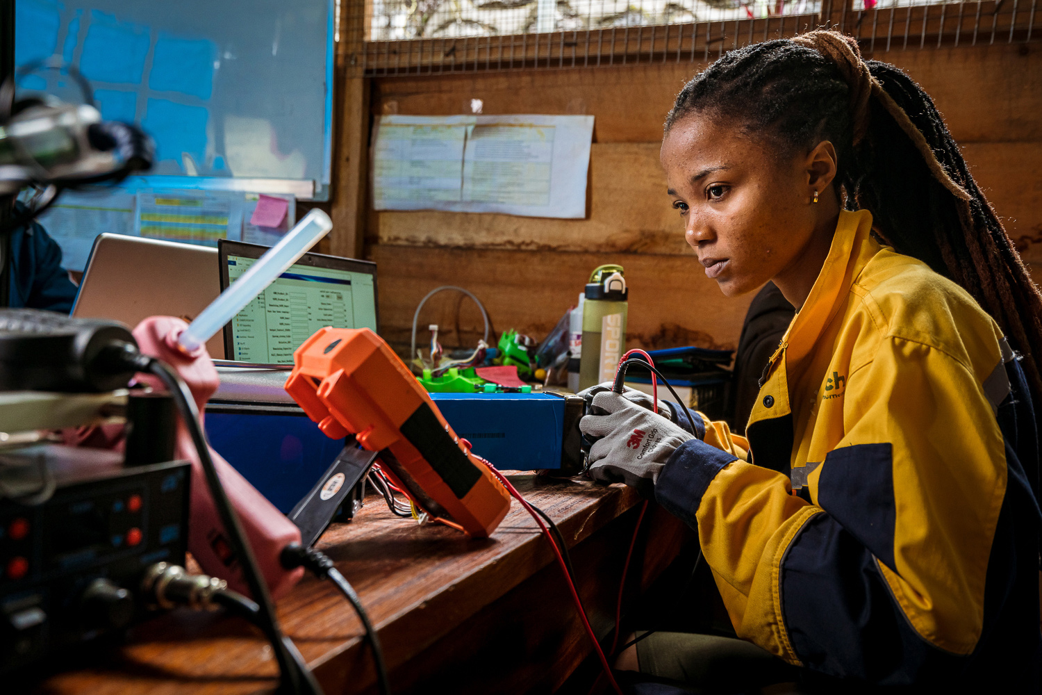 A woman works on a battery in an office