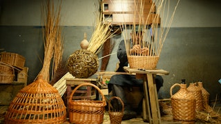 A man weaving a basket by hand
