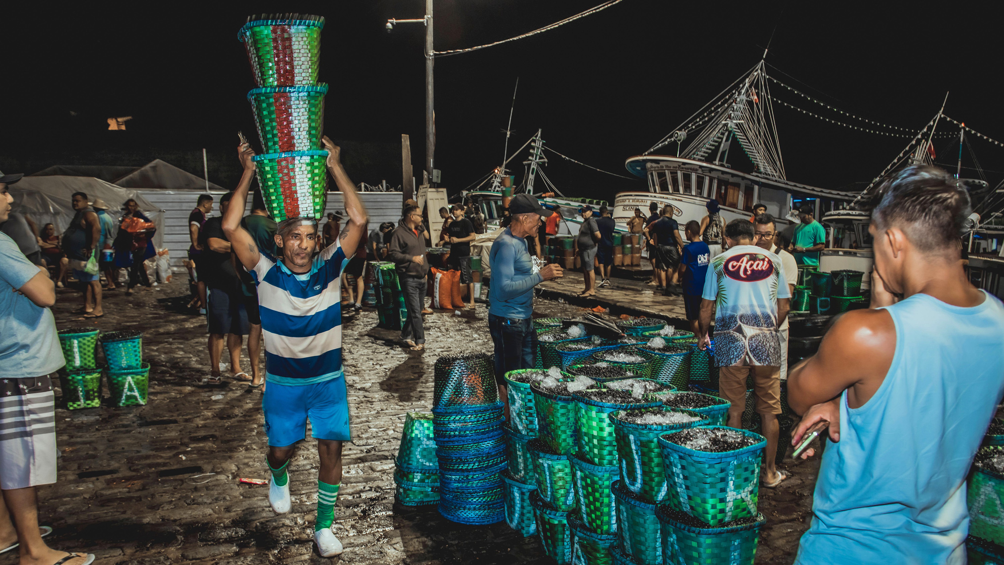 Acai berries being packed and carried in a night market