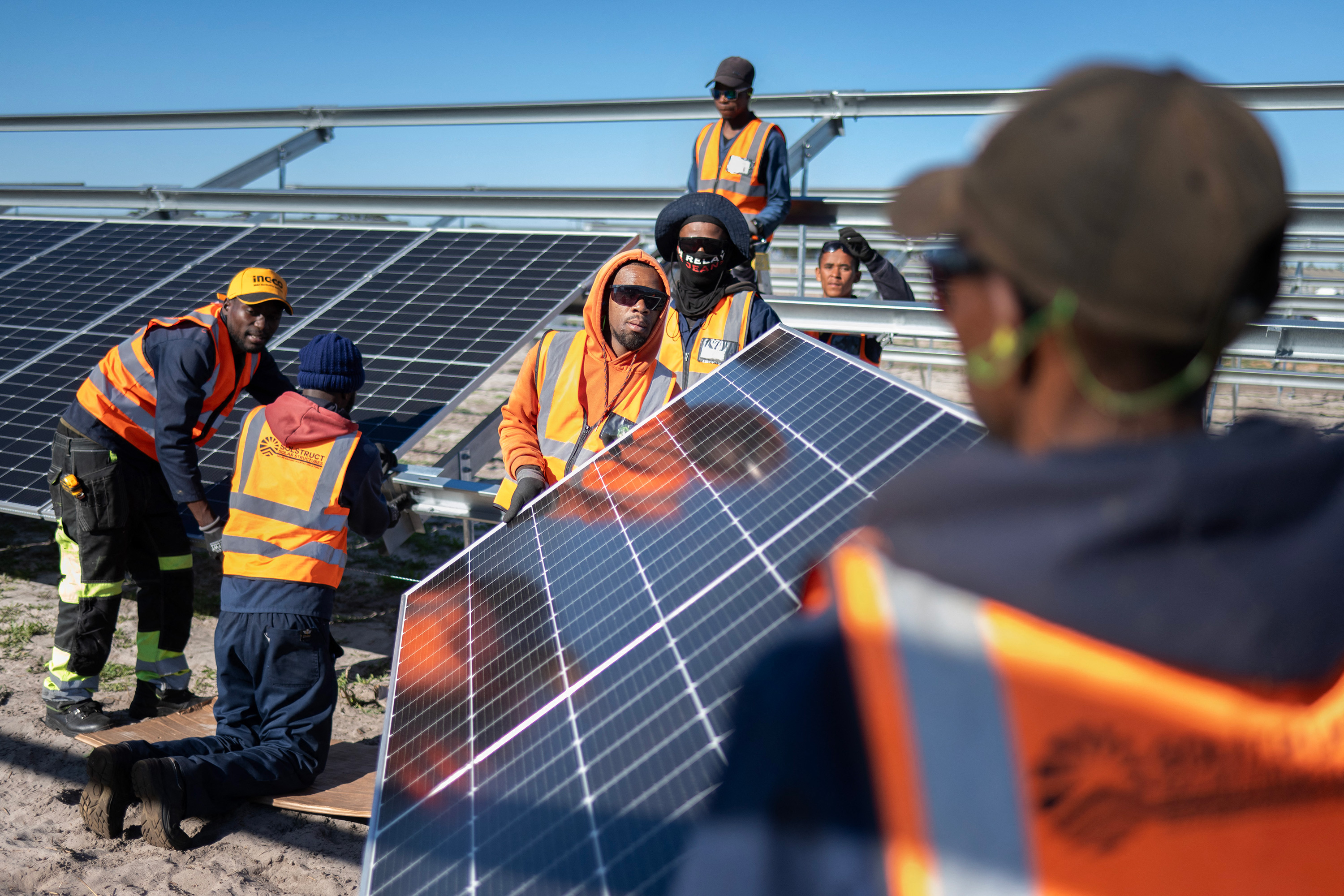 Workers at a solar panel array