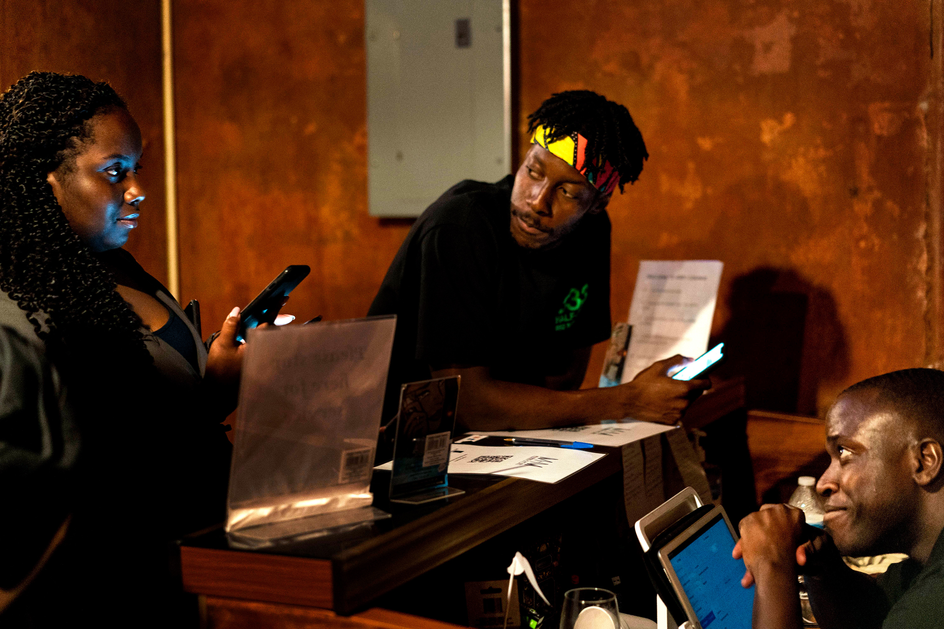 Three people gather around a desk